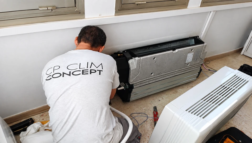 Techniciens sur toiture plate entretenant deux unités extérieures de climatisation split-system